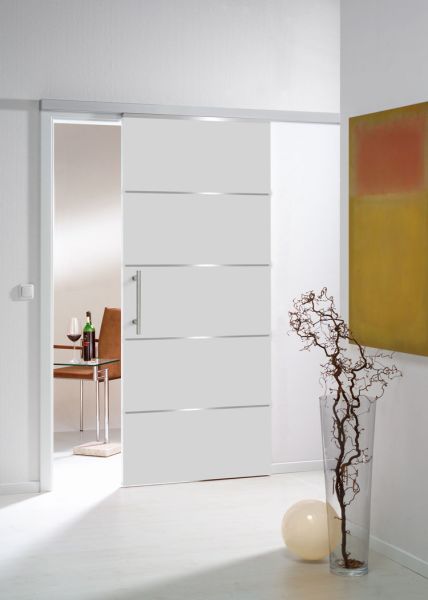 Porte coulissante blanche ouverte, révélant une salle à manger moderne avec une table et des chaises.