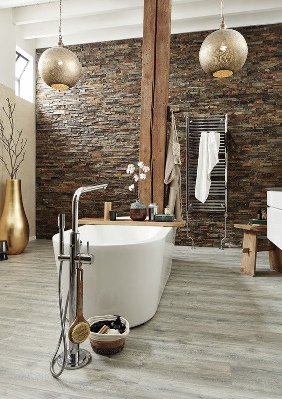 Baignoire blanche élégante, entourée d'éléments décoratifs modernes dans une salle de bain lumineuse.