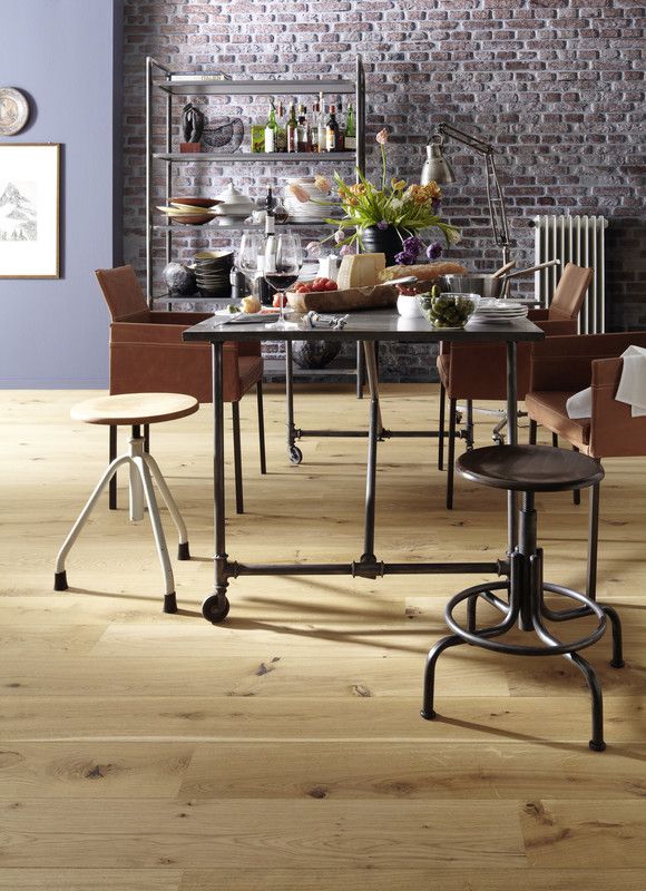 Table en métal au centre, entourée de chaises, avec des plats et des fleurs dessus.