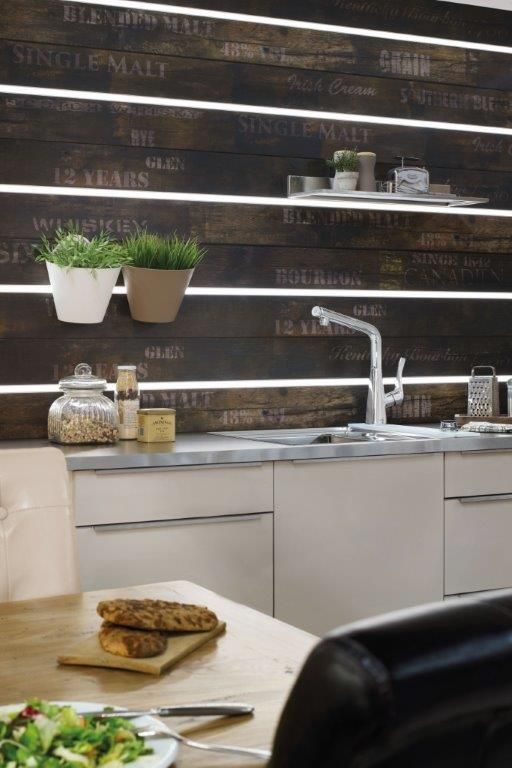 Cuisine moderne avec évier, plantes décoratives et éléments en bois, créant une ambiance chaleureuse.