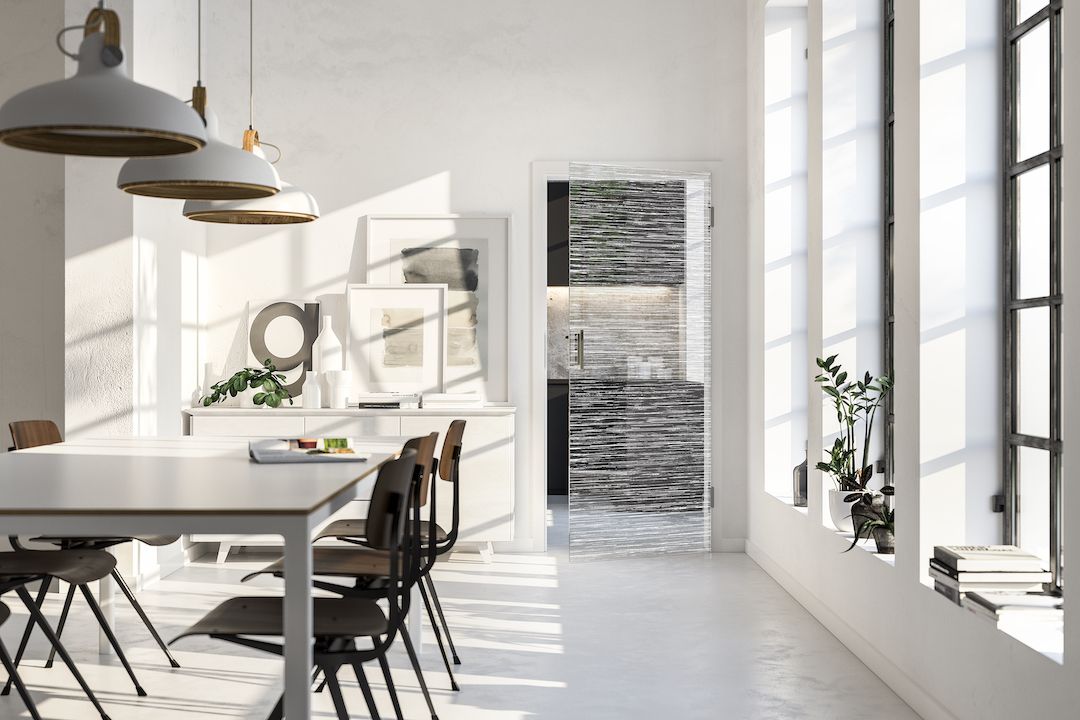 Salle à manger lumineuse avec une table, des chaises, des plantes et une porte vitrée.