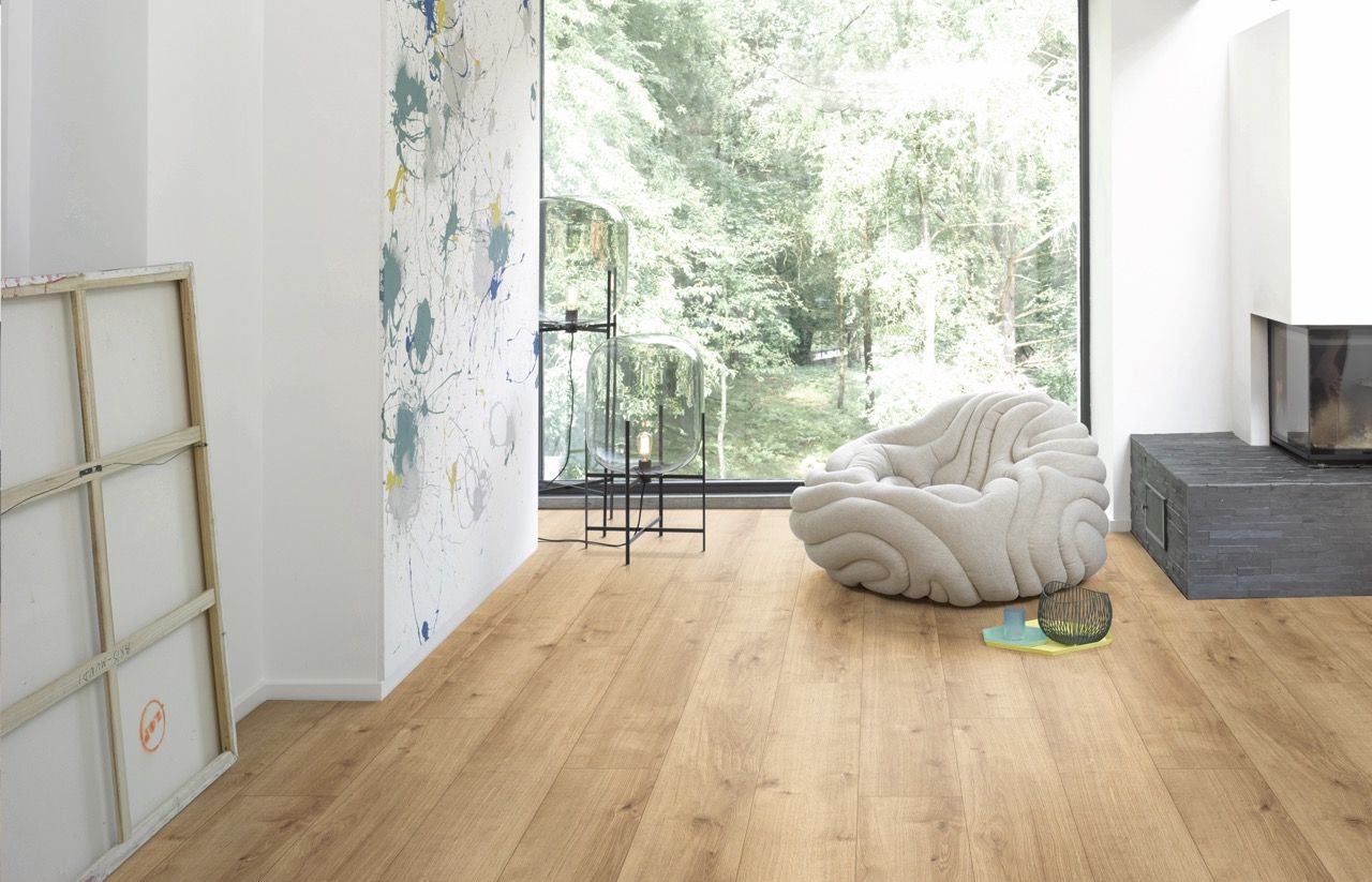 Un fauteuil en forme organique se trouve dans un salon lumineux avec vue sur la nature.