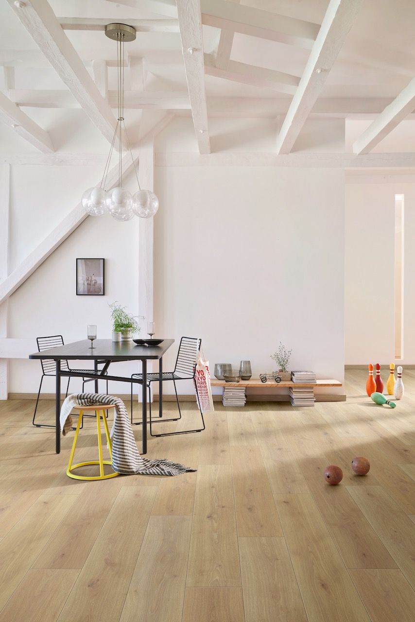 Table noire avec chaises, décorée, dans un espace lumineux, avec des objets de loisirs.