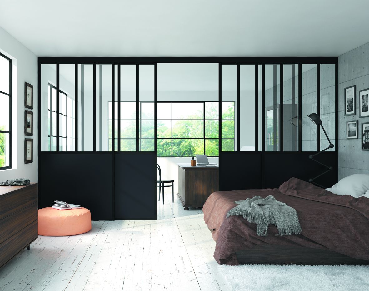 Chambre moderne avec un lit, un espace de travail et une séparation en verre noir.