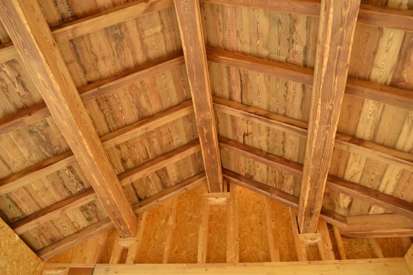 Plafond en bois avec poutres apparentes, créant une ambiance chaleureuse et naturelle dans l'espace.