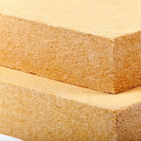 Panneaux de fibres, empilés, montrant une texture rugueuse et naturelle, utilisés en construction.