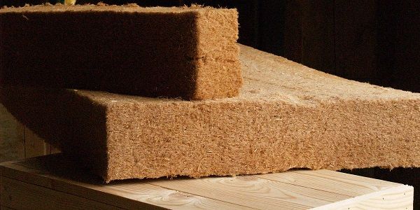 Matériaux isolants en fibres, empilés, montrant leur texture et épaisseur, prêts pour l'utilisation.