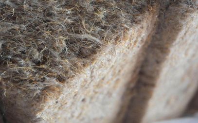 Un morceau de matériau en fibres, présentant une texture douce et feutrée, éclairé latéralement.
