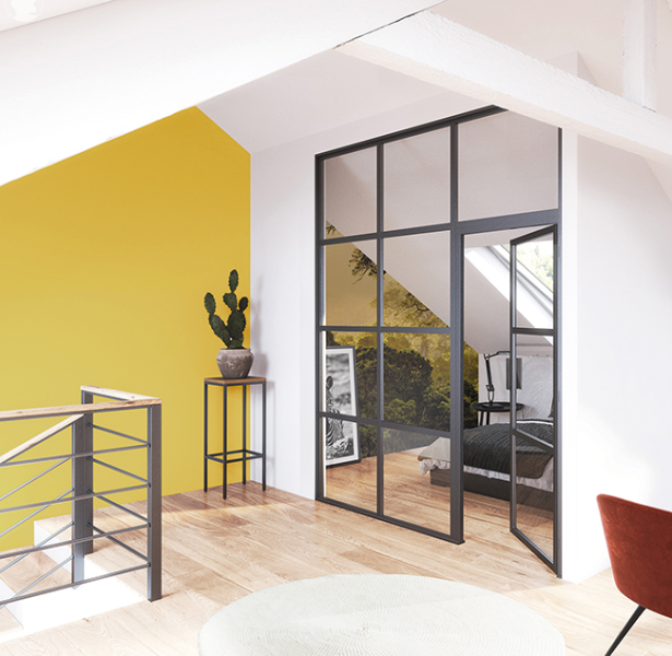 Espace intérieur moderne avec un mur jaune, des plantes et des portes vitrées menant à une chambre.